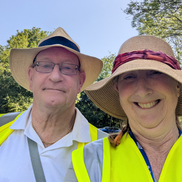 Two BVA Buddies smiling at the camera, both wearing hats and high vis vests
